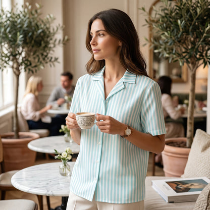 Good Wishes 365 mint and white candy stripe short sleeve button-up shirt with a camp collar, worn in a cafe setting.