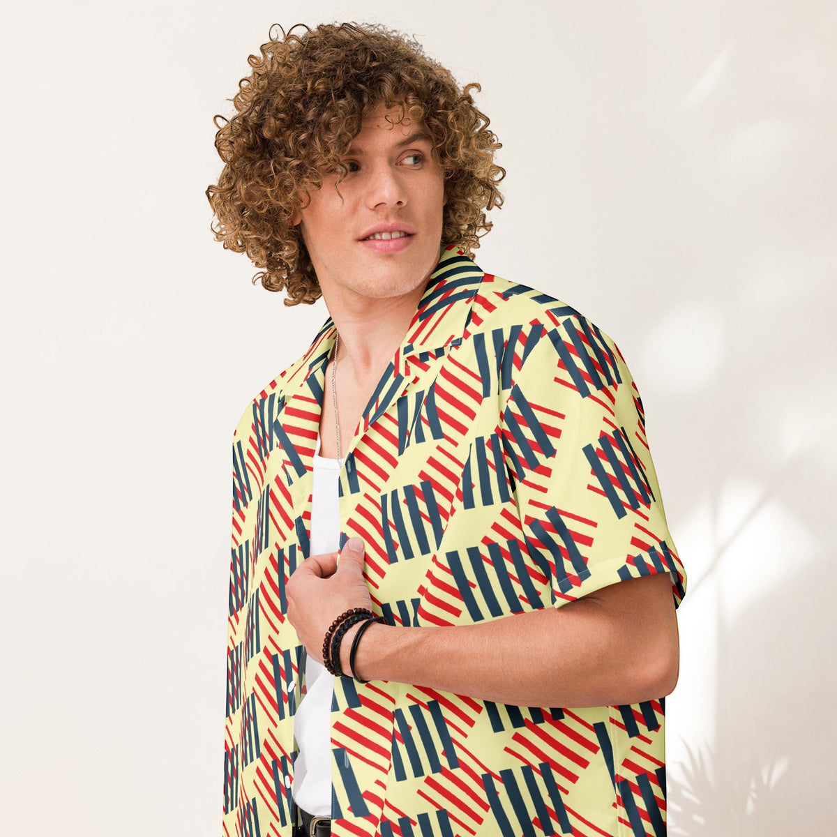 Good Wishes 365 men's short sleeve button-down shirt with a geometric red, navy, and cream print and camp collar. All-over print, unisex button shirt, close side view. 