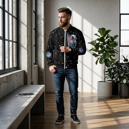 Good Wishes 365 unisex black bomber jacket with astronaut and moon landing print worn by a man in a bright room.