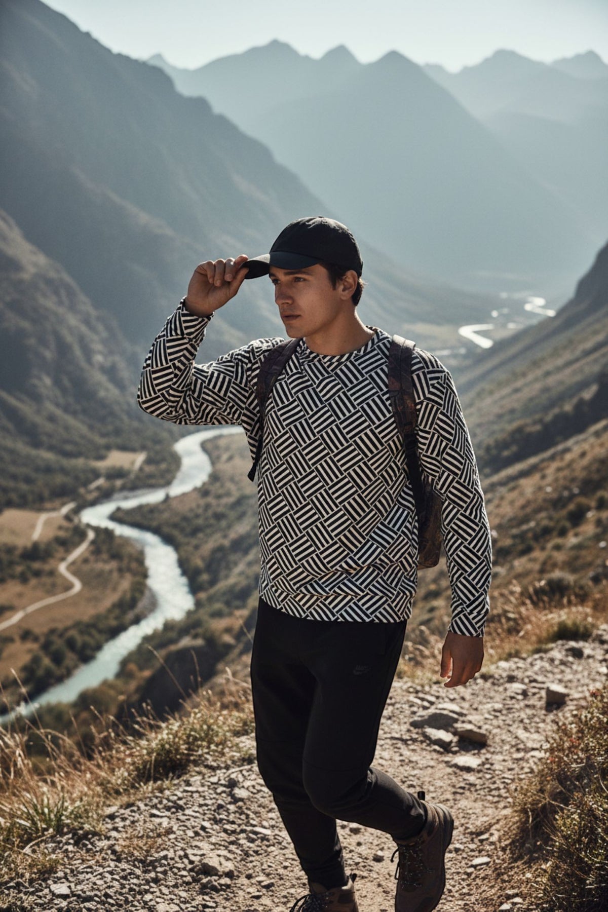 Good Wishes 365 unisex sweatshirt with black and white basketweave pattern worn by a man hiking in the mountains.