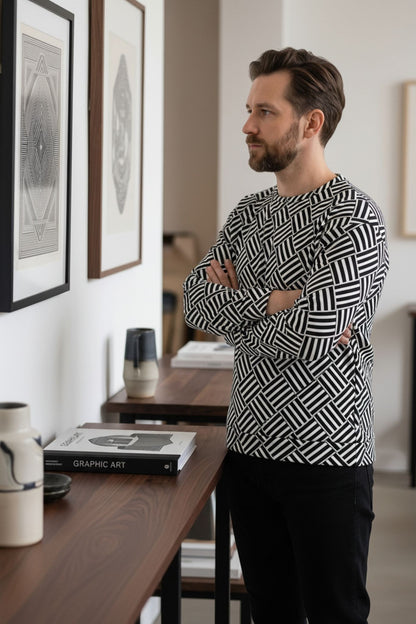 Man wearing a Good Wishes 365 black and white basketweave geometric print crewneck sweatshirt in a modern gallery.