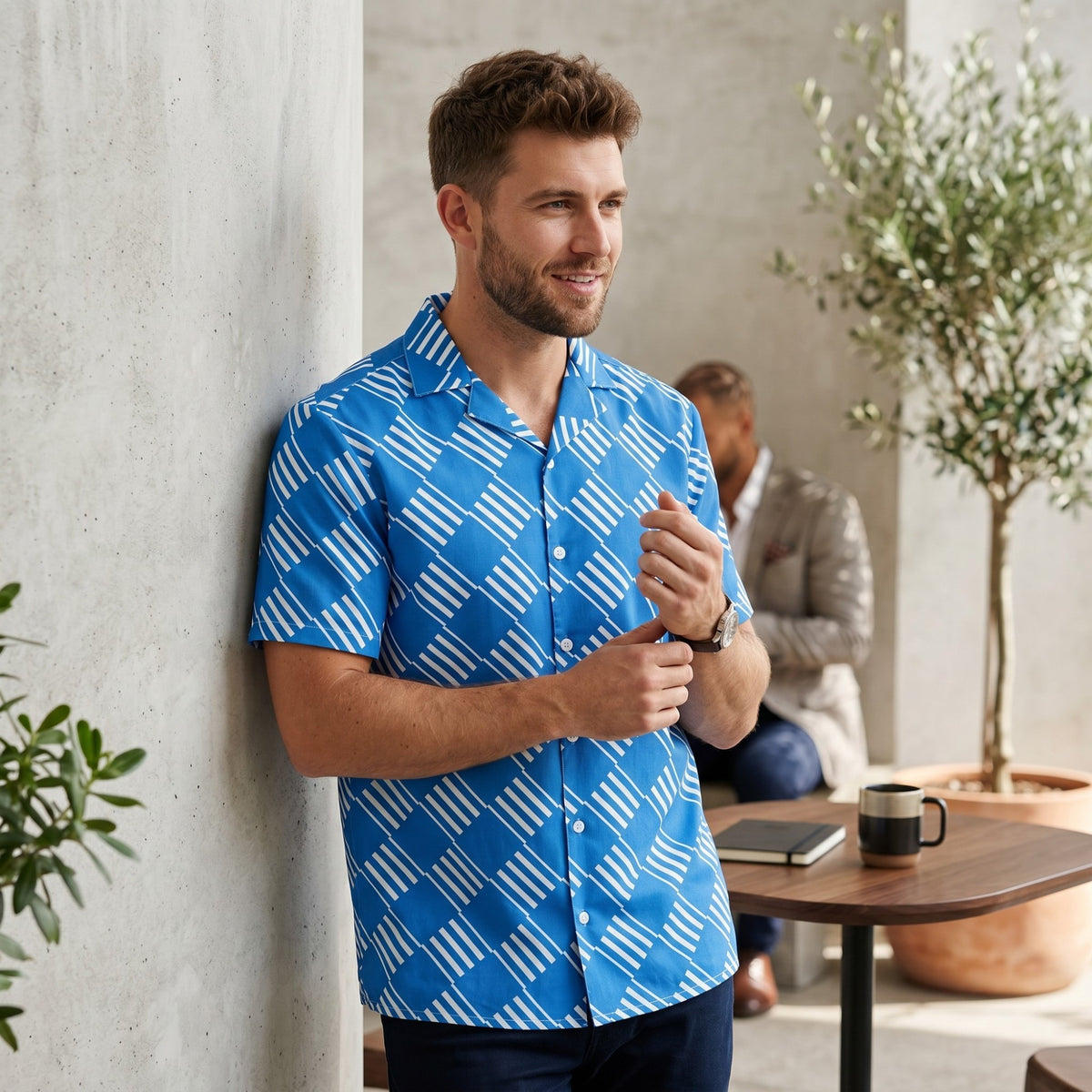 Good Wishes 365 blue short sleeve button down shirt with white geometric pattern and camp collar on a male model