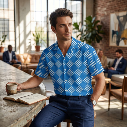 Good Wishes 365 blue short sleeve button down shirt with white geometric pattern and camp collar on a man in a cafe