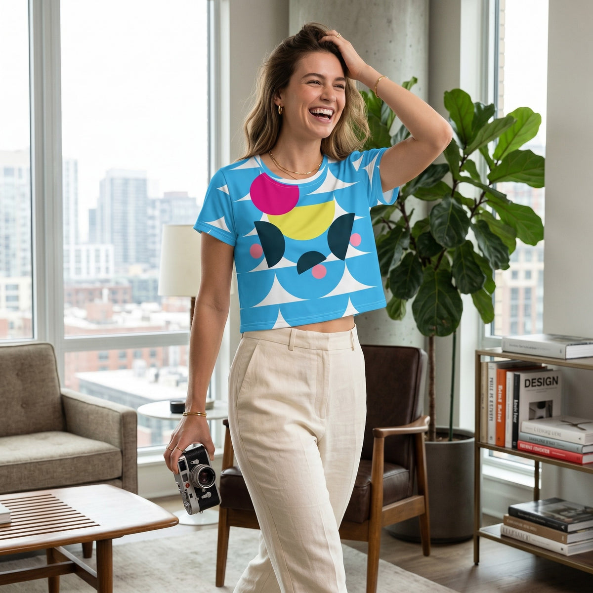 Good Wishes 365 deep sky blue crop tee with mushroom-inspired geometric print worn by a smiling woman in a bright room