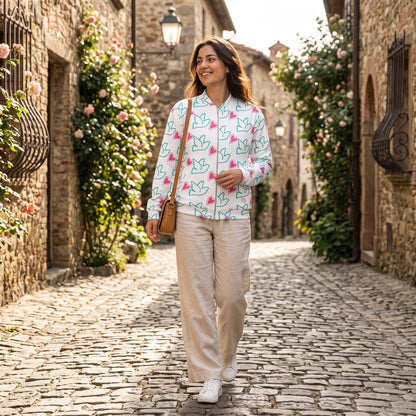 Good Wishes 365 unisex bomber jacket with peace sign and heart print worn by a woman on a cobblestone street