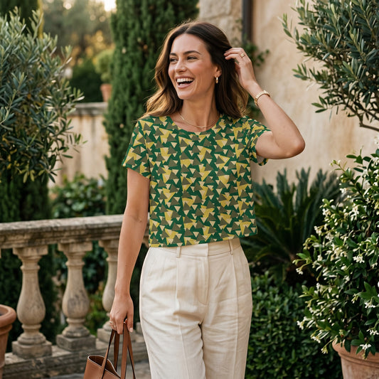A woman smiling while wearing a Good Wishes 365 green and yellow geometric camouflage print crop tee outdoors.