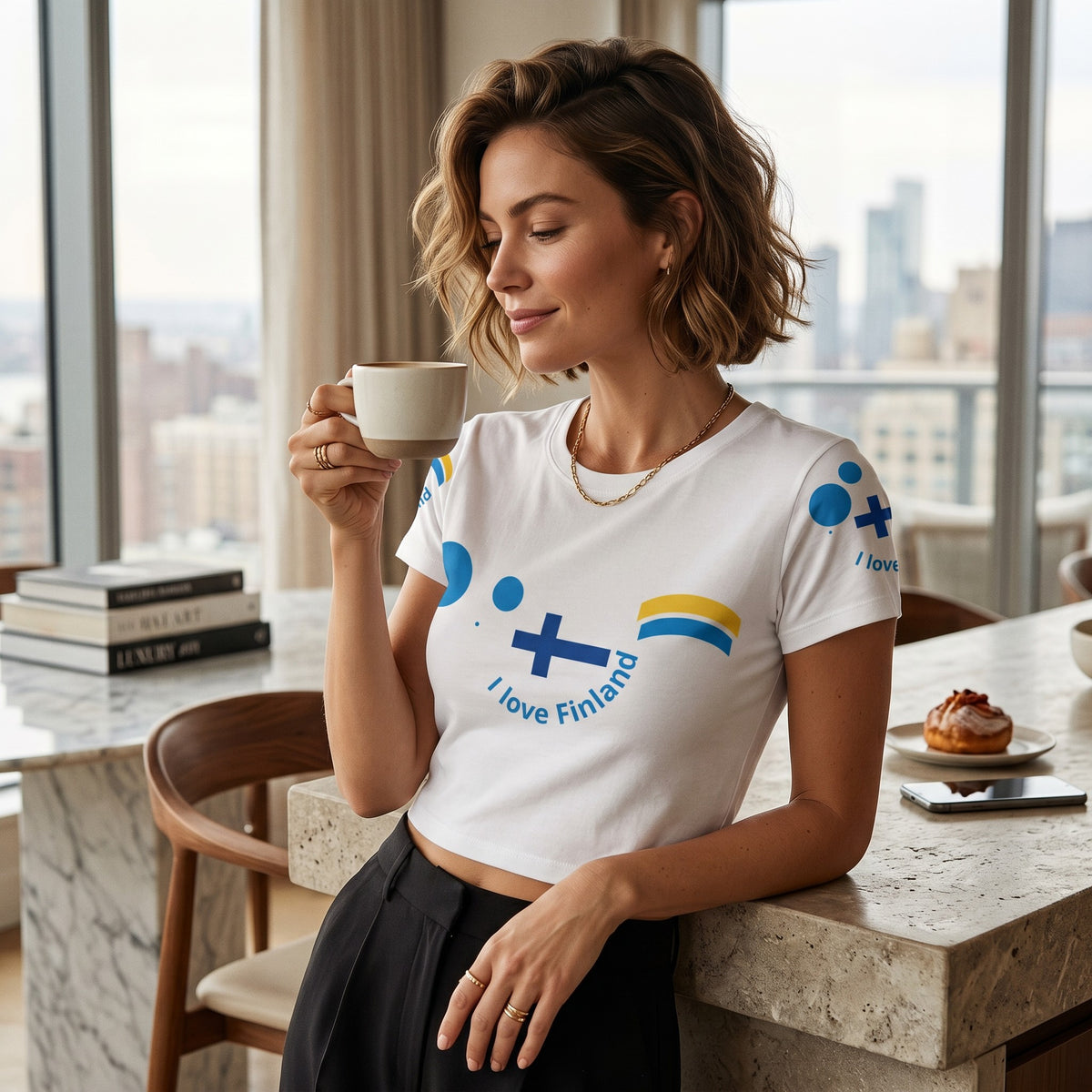 Good Wishes 365 white crop tee with Finnish flag and I love Finland print worn by a woman holding a coffee cup