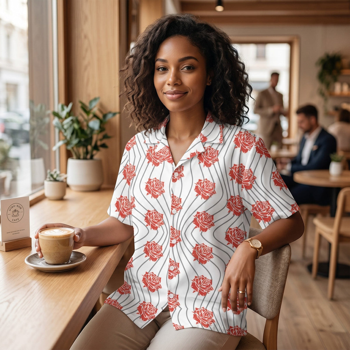 Good Wishes 365 unisex button up shirt with red rose floral print and wavy lines on a woman sitting in a cafe.