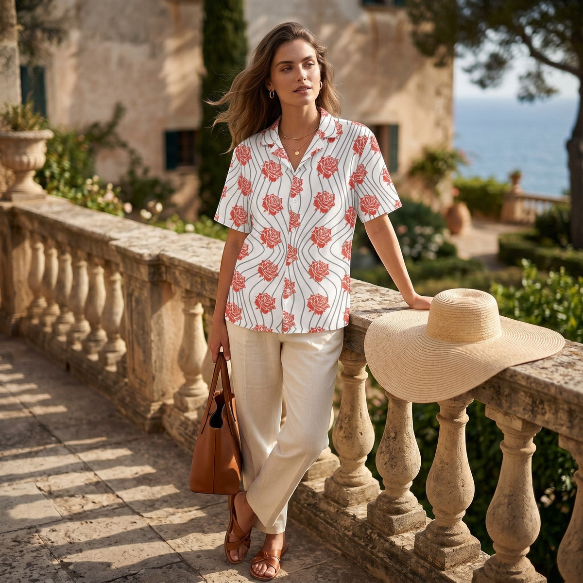 Good Wishes 365 unisex button-up shirt with red rose floral print and wavy lines, worn by a woman on a stone terrace.