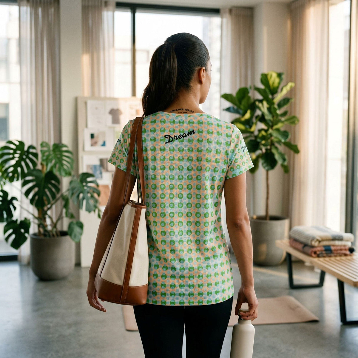 Good Wishes 365 athletic t-shirt with green and blue geometric print, featuring Dream logo on back, worn by a woman.