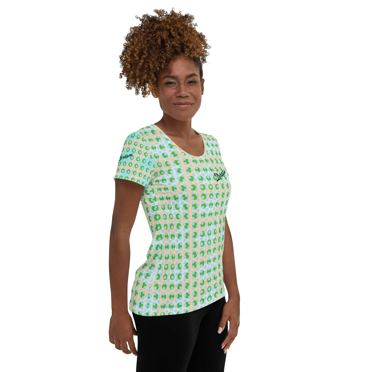 Good Wishes 365 athletic t-shirt with green and blue geometric pattern worn by a woman with curly hair