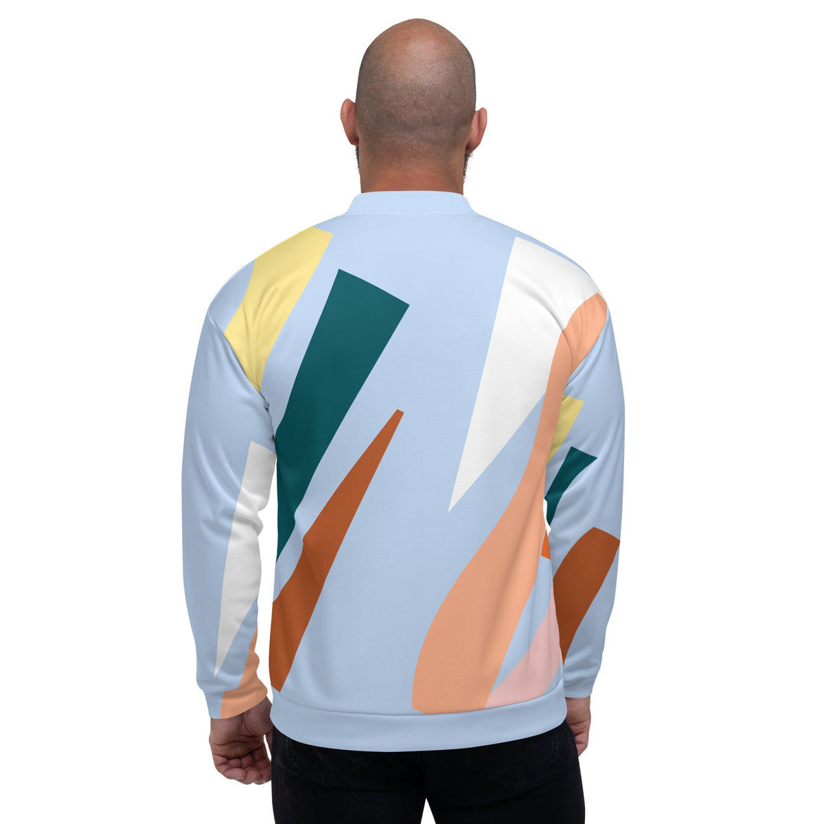 Back view of a man wearing a Good Wishes 365 unisex bomber jacket with a pastel blue and geometric earth tone print.