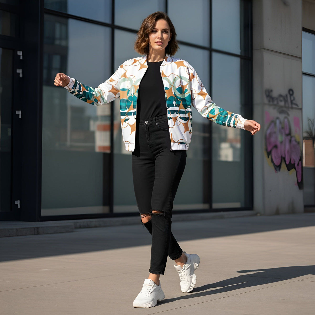 Good Wishes 365 women's bomber jacket with geometric geo-stars print in teal, sage, and ochre on a white base.