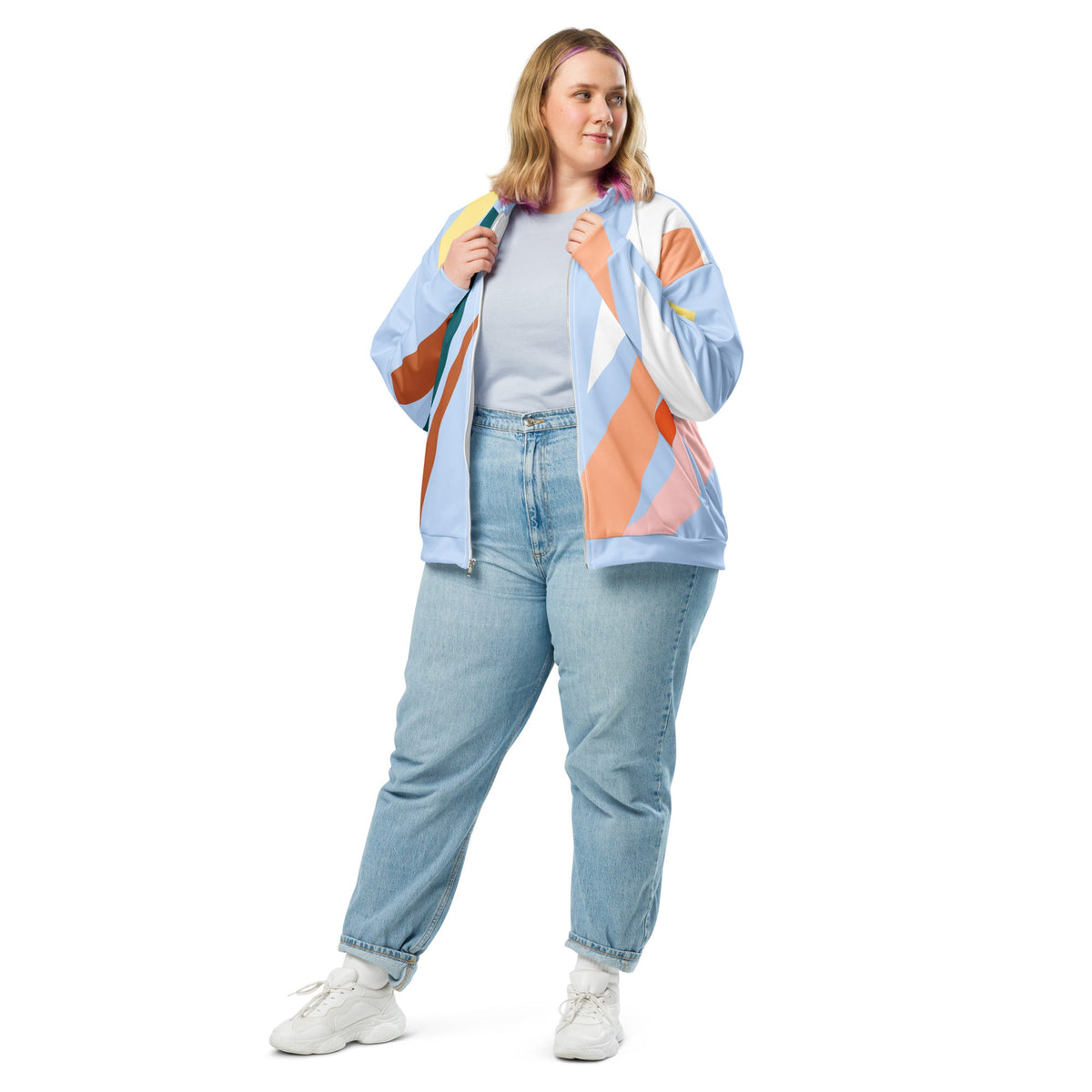 Good Wishes 365 women's bomber jacket with pastel and earth tone abstract geometric print, worn with jeans and sneakers.