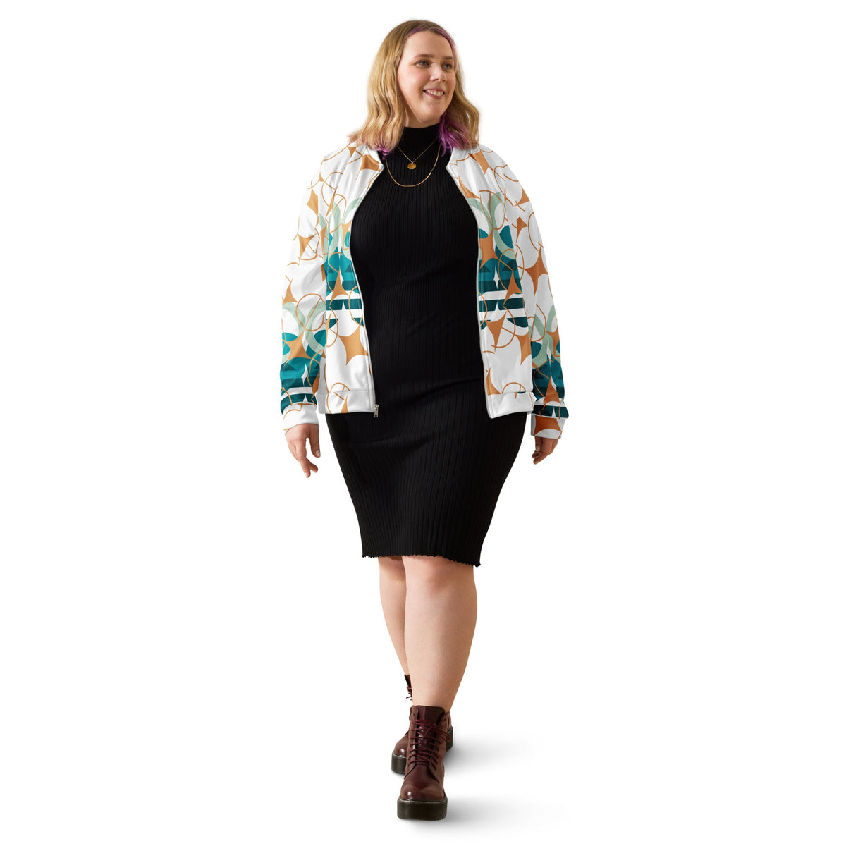 Good Wishes 365 geometric bomber jacket in white with teal, sage, and ochre stars worn by a woman in a black dress.