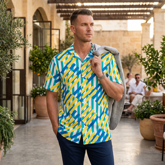 Good Wishes 365 unisex button shirt with a vibrant yellow, blue, and white geometric pattern in an outdoor setting.