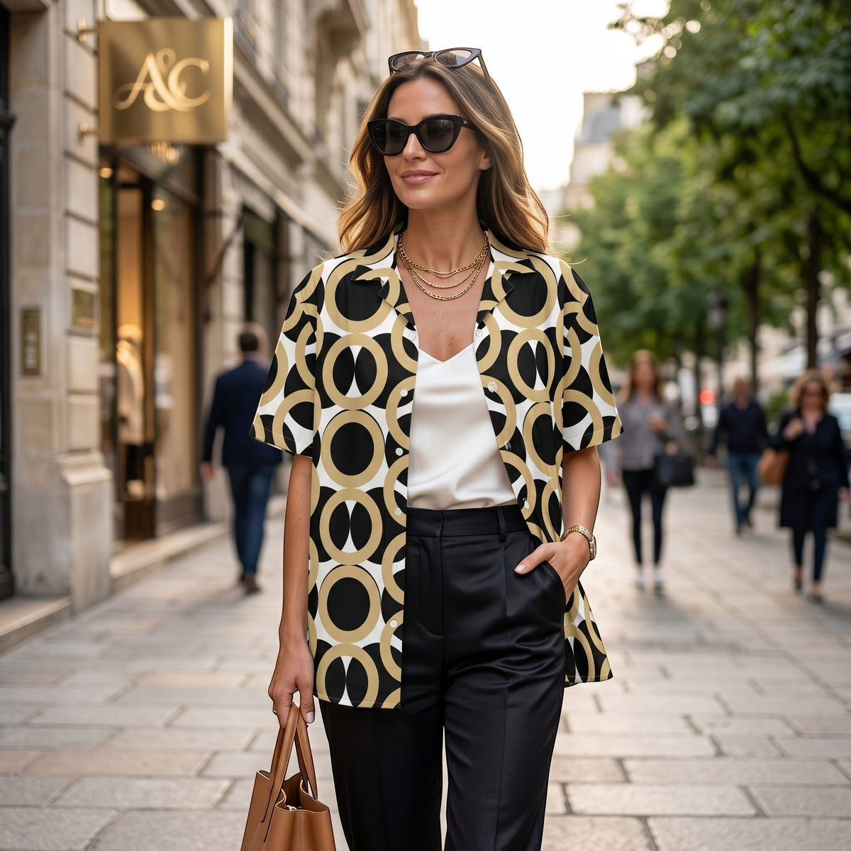 Good Wishes 365 unisex button shirt with retro geometric print in black, gold, and cream worn open over a white top.