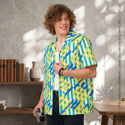 Good Wishes 365 unisex oversized button shirt with a yellow, blue, and green geometric pattern worn by a curly-haired man.