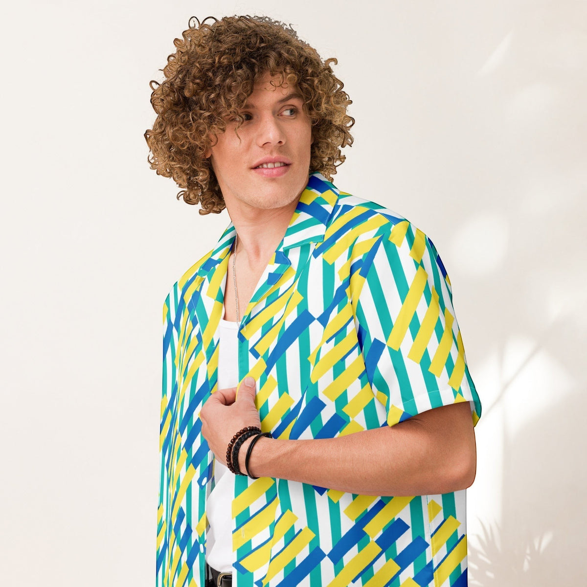 Good Wishes 365 unisex oversized button-up shirt with a colorful geometric pattern in blue, yellow, and green. Short sleeves, collared.