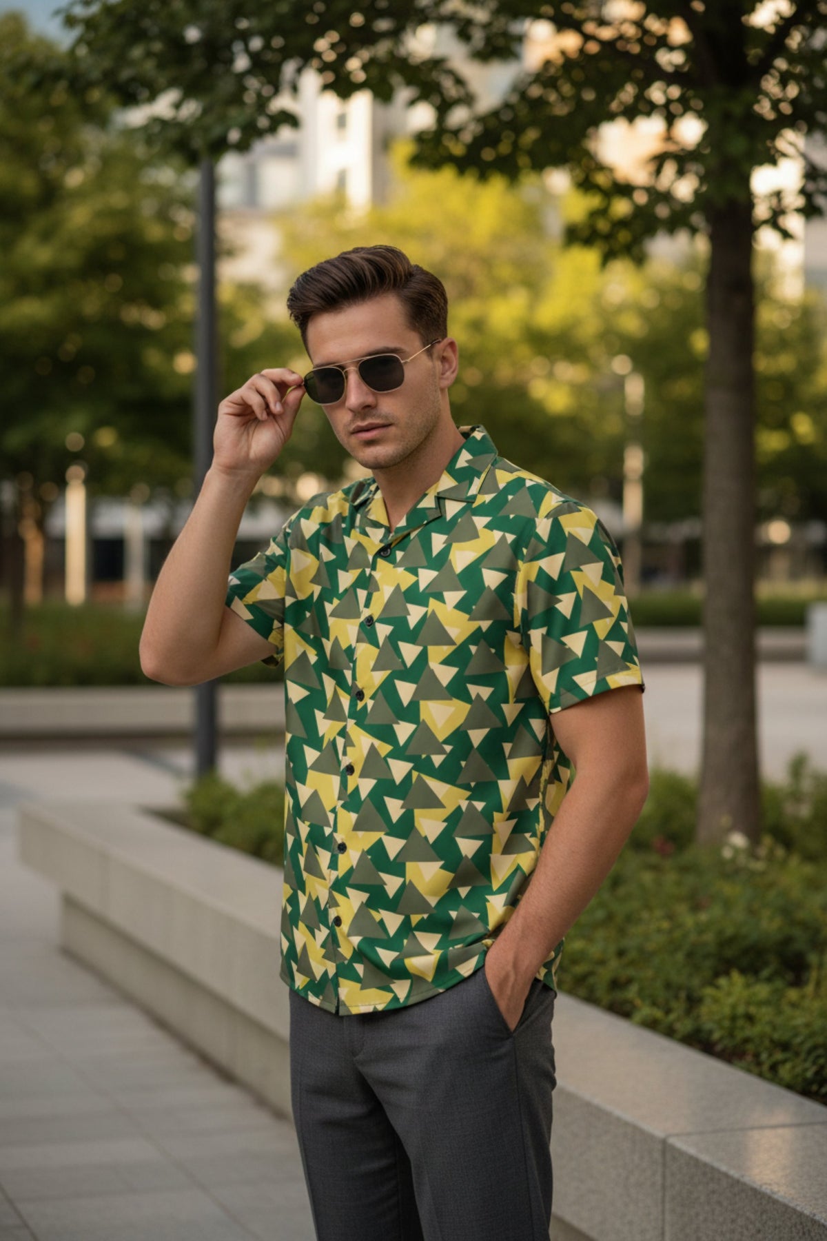 Good Wishes 365 Men's short sleeve button-down shirt with geometric green, yellow, and olive triangle camo print. Recycled polyester blend.