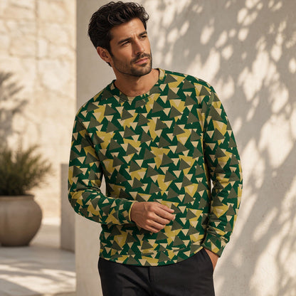 A man wearing a Good Wishes 365 recycled sweatshirt with a green and yellow geometric camo print in a sunny setting.