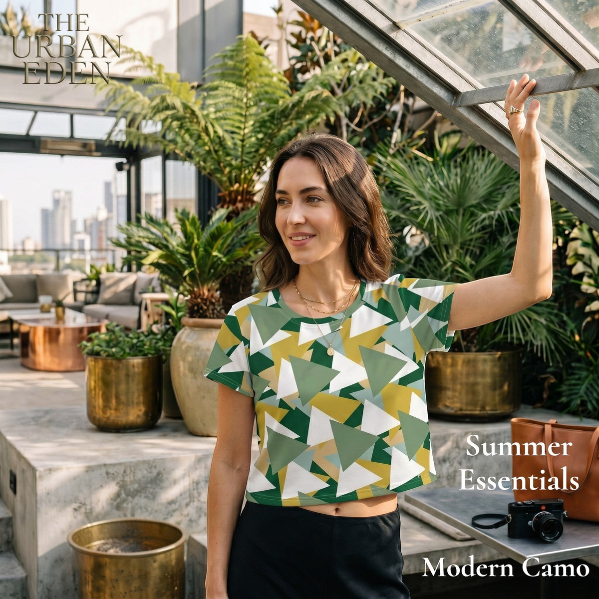 Good Wishes 365 crop tee with green and white geometric camouflage print worn by a woman in a sunny greenhouse.