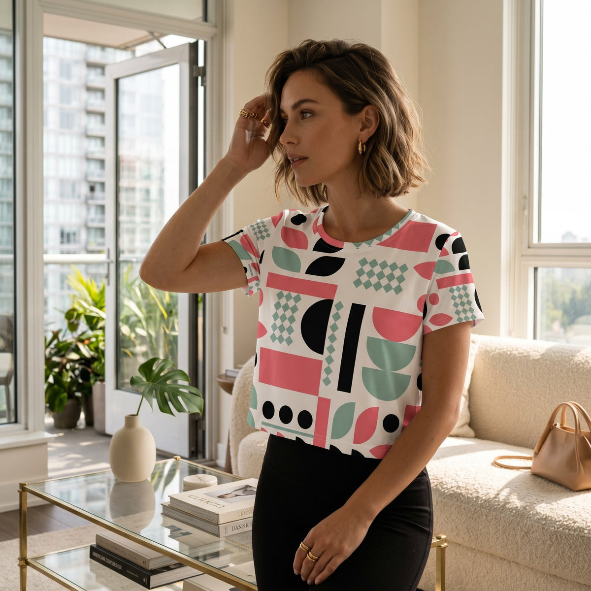 Good Wishes 365 crop tee with mint, red, and black geometric print worn by a woman in a bright living room