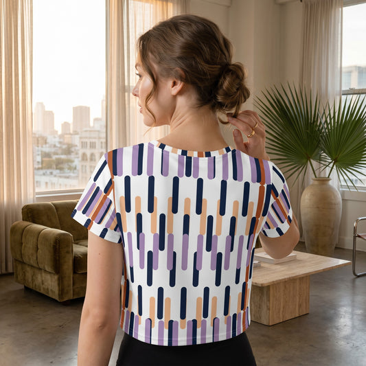 Good Wishes 365 crop tee featuring a white base with a geometric vertical stripe pattern in purple, navy, and peach.
