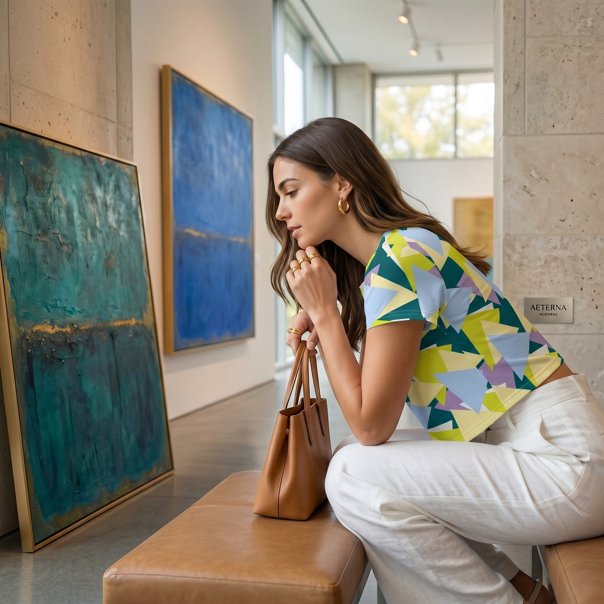 Good Wishes 365 model wearing a multi-colored geometric crop tee with white trousers in an art gallery.