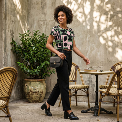 Good Wishes 365 crop tee with pink, green, and black geometric print worn by a woman in a cafe setting.