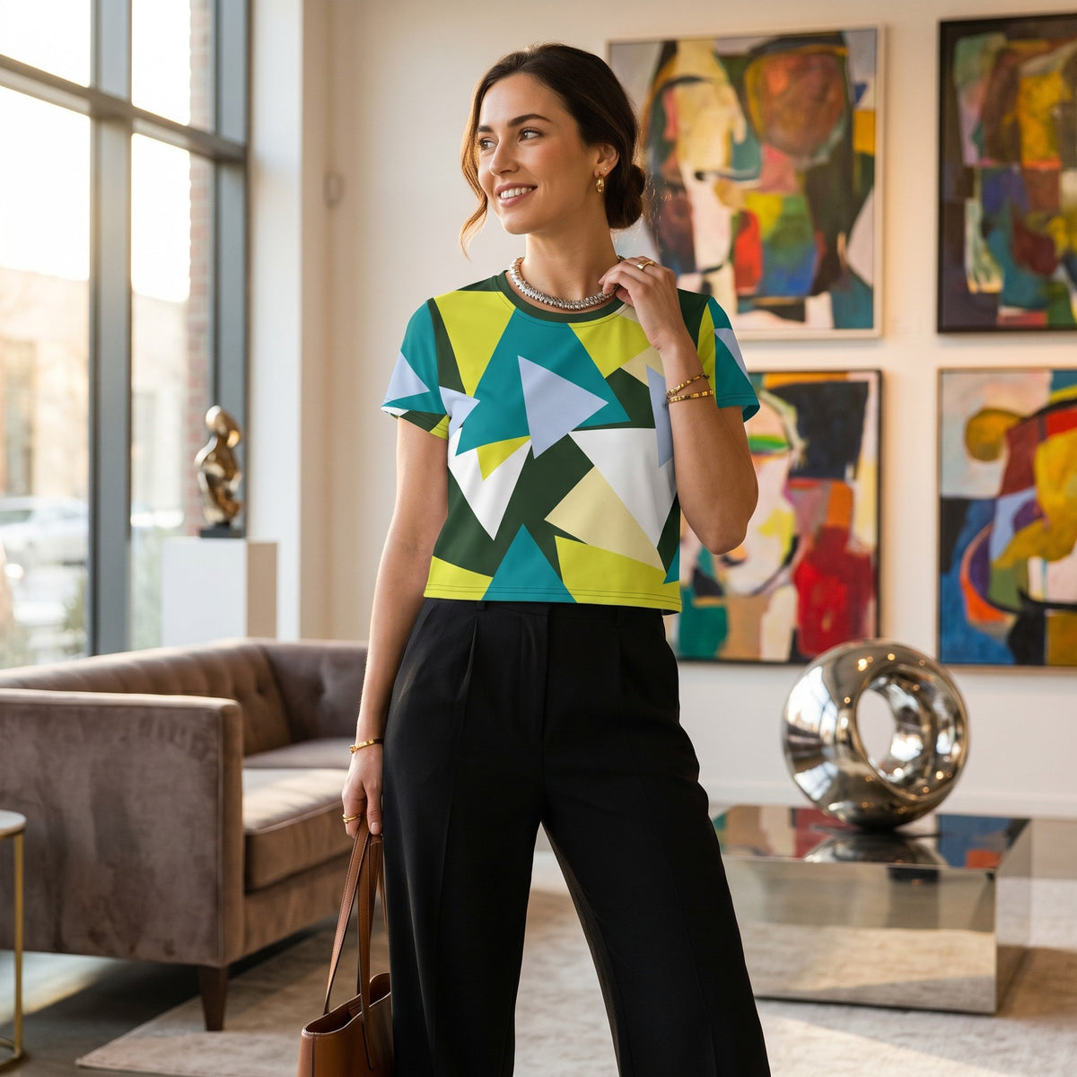 Good Wishes 365 woman wearing a geometric all-over print crop tee with green, blue, and white triangles in an art gallery