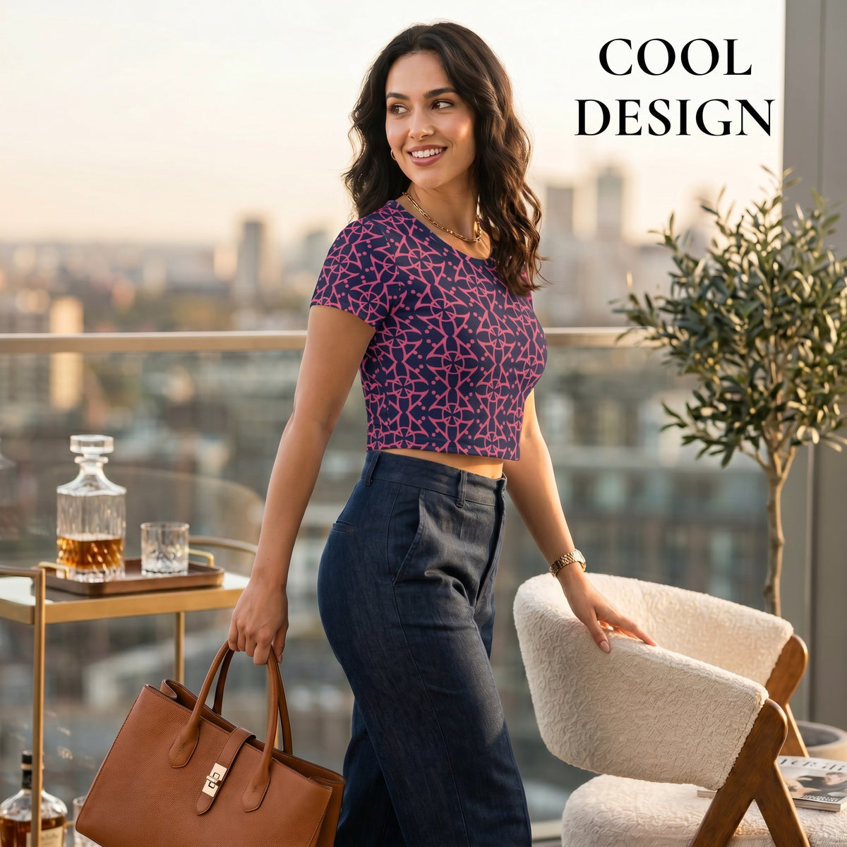 Good Wishes 365 crop tee with purple and pink geometric all-over print worn by a woman on a city balcony
