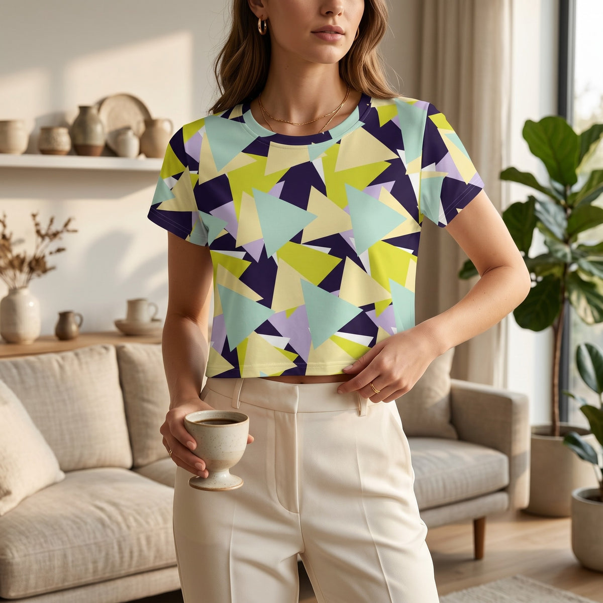Good Wishes 365 crop tee with a geometric triangle pattern in pastel yellow, purple, and teal, worn by a woman.