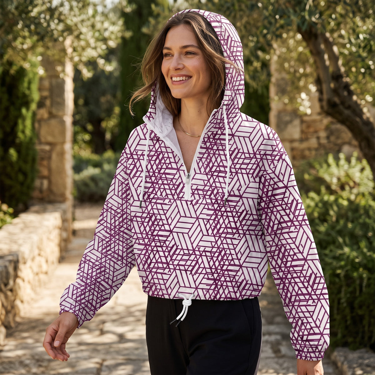 Good Wishes 365 women's cropped windbreaker with purple geometric trapezoidal print, half-zip, and hood in a garden.