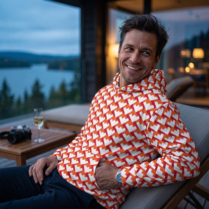 Good Wishes 365 unisex hoodie with red and orange geometric heart pattern, worn by a man on a balcony at dusk.