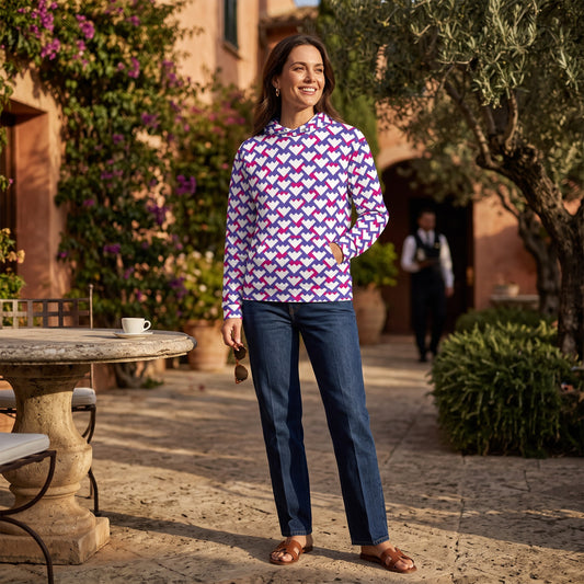 Good Wishes 365 unisex hoodie with purple and red geometric heart pattern, worn by a woman in a sunny outdoor courtyard