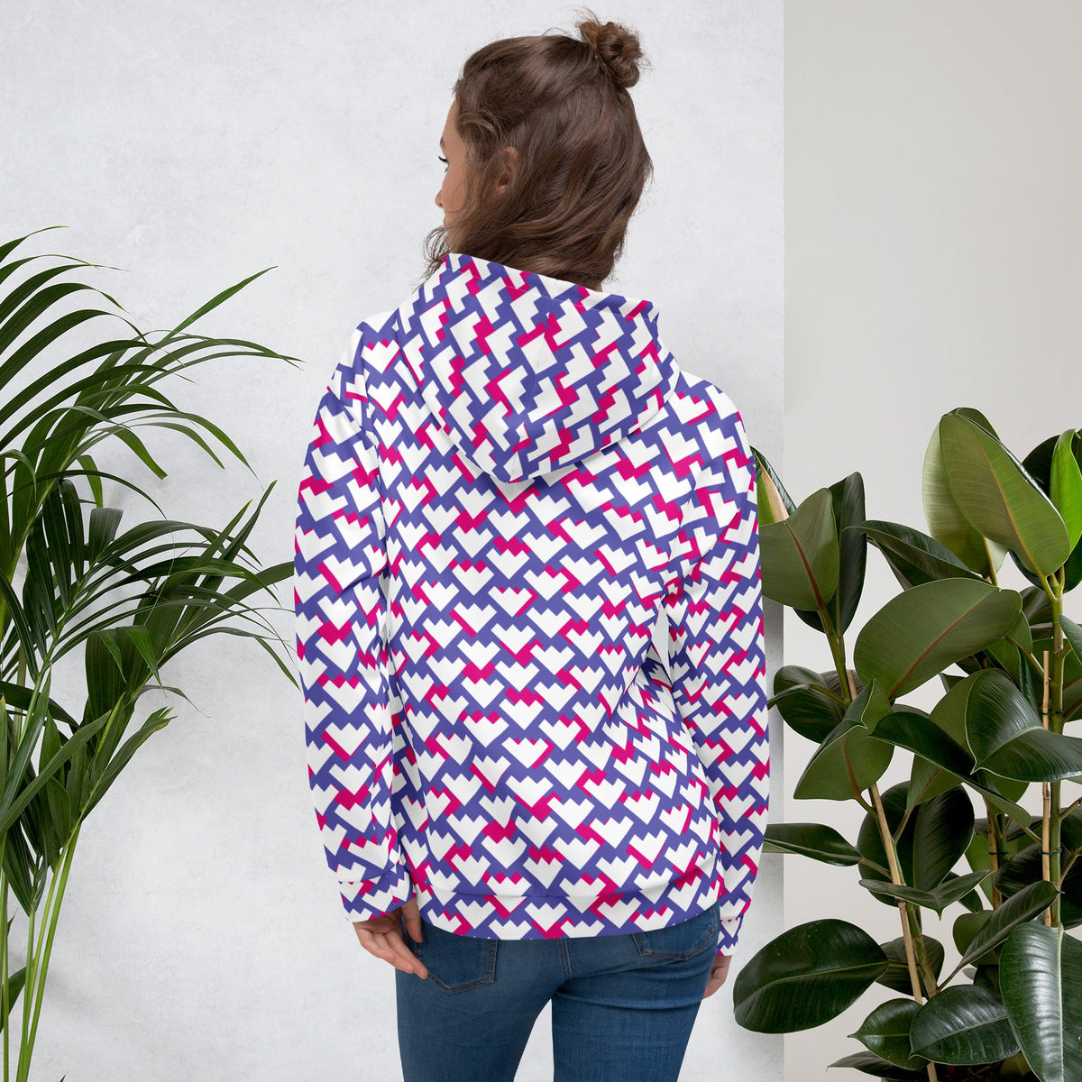 Woman wearing a Good Wishes 365 recycled unisex hoodie with a purple, violet, and red geometric heart pattern.