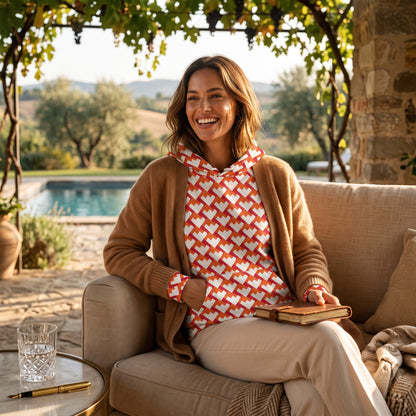 Good Wishes 365 unisex hoodie with a red and orange geometric heart pattern, worn by a woman with a tan cardigan.