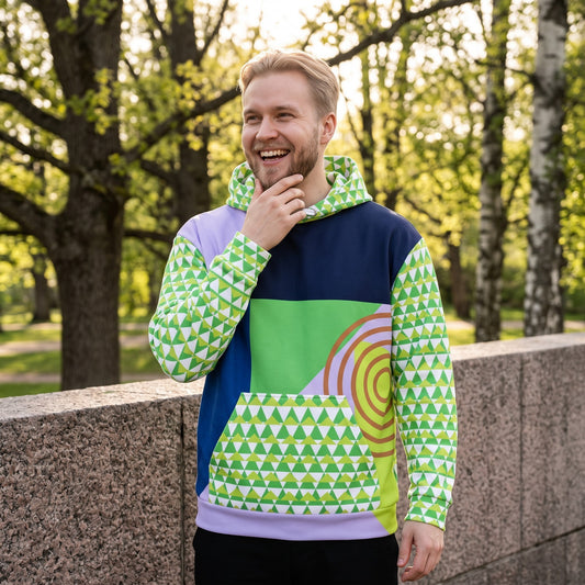 Good Wishes 365 men's recycled hoodie with 80s Memphis geometric print in green, navy, and lavender outdoors.