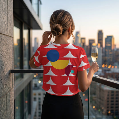Good Wishes 365 crop tee with red geometric mushroom pattern worn by a woman on a balcony at sunset
