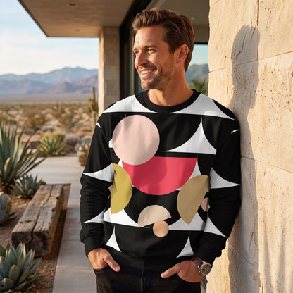 A man wearing a Good Wishes 365 black recycled sweatshirt with a geometric mushroom graphic in a desert setting.