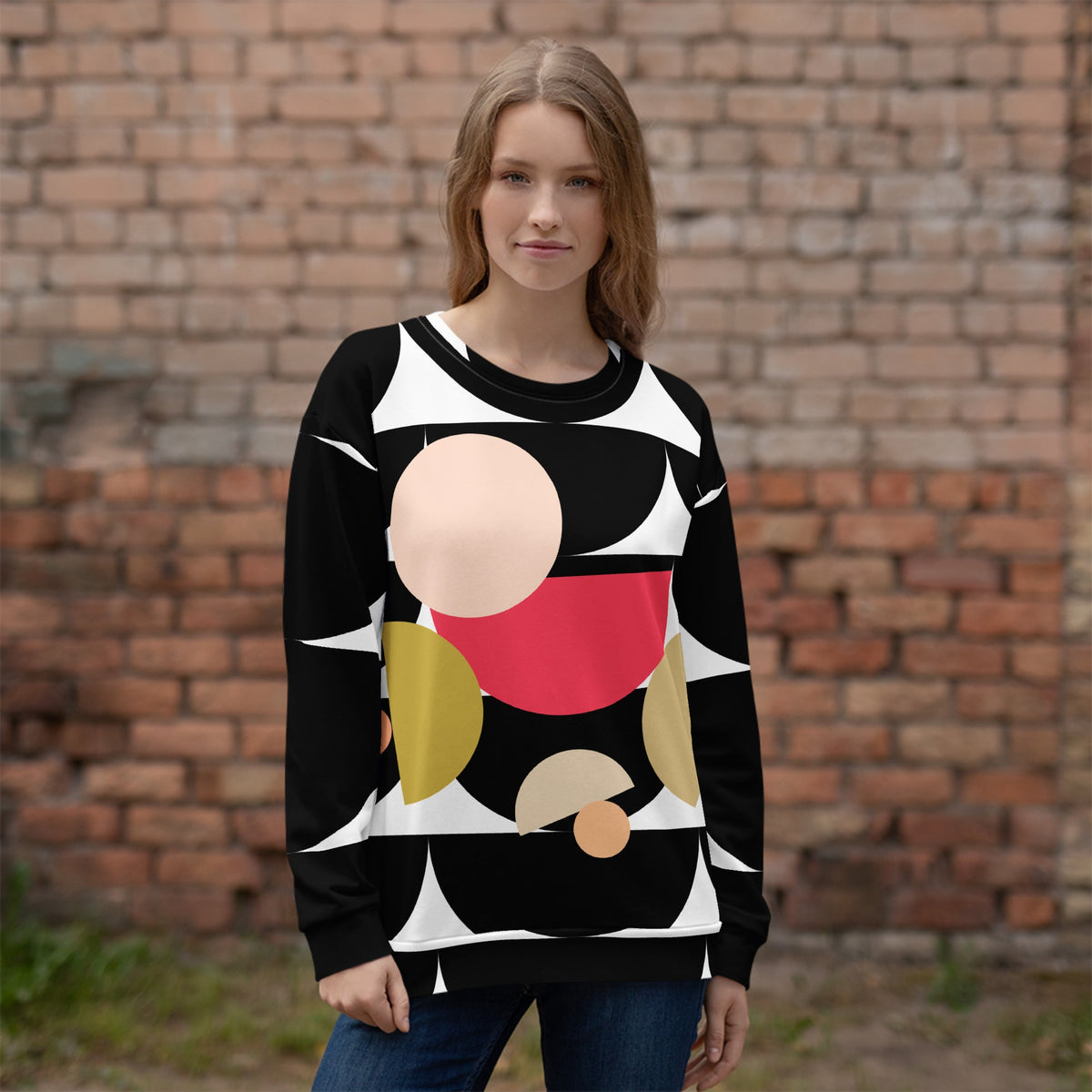 Good Wishes 365 black recycled sweatshirt with geometric mushroom graphic print worn by a woman against a brick wall.