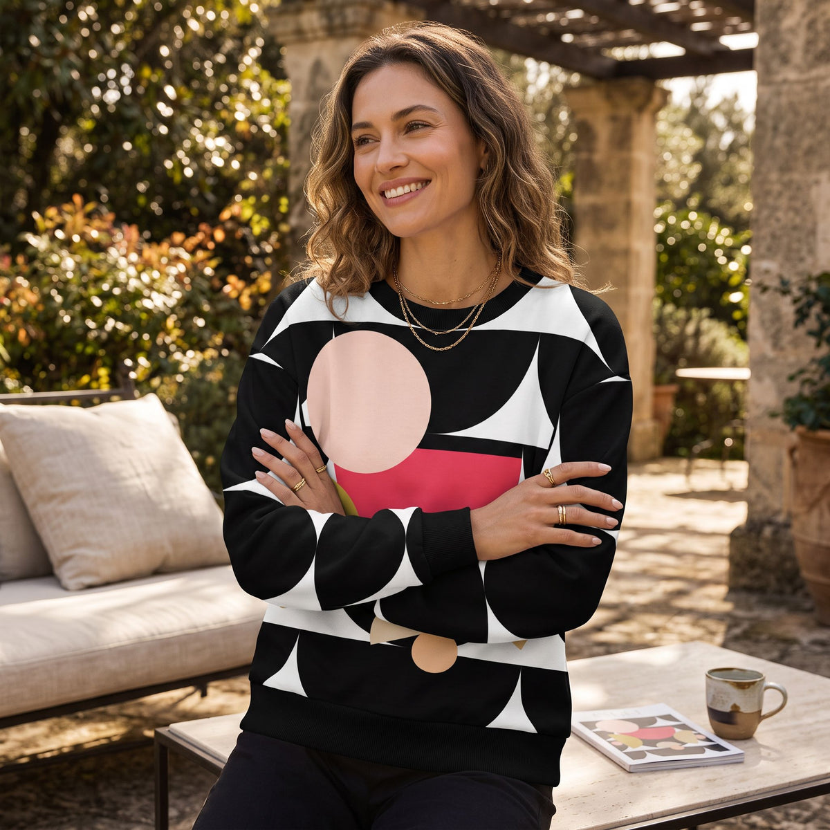 Good Wishes 365 black recycled sweatshirt with geometric mushroom graphic print worn by a woman in a garden setting.