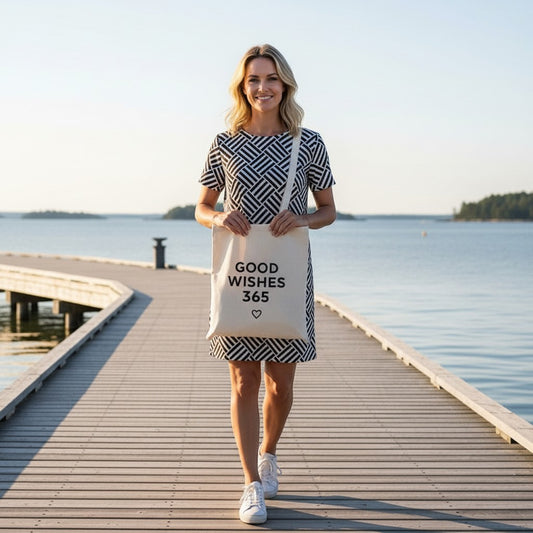Good Wishes 365 woman in black and white geometric pattern t-shirt dress with tote bag on wooden pier