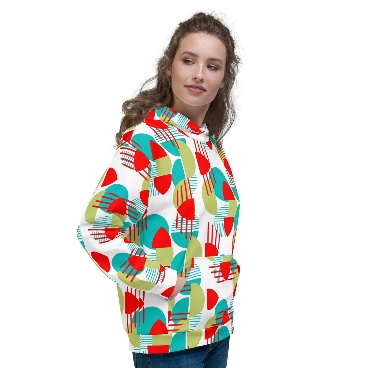 A woman wearing a Good Wishes 365 recycled hoodie with a vibrant red, green, and teal geometric all-over print.