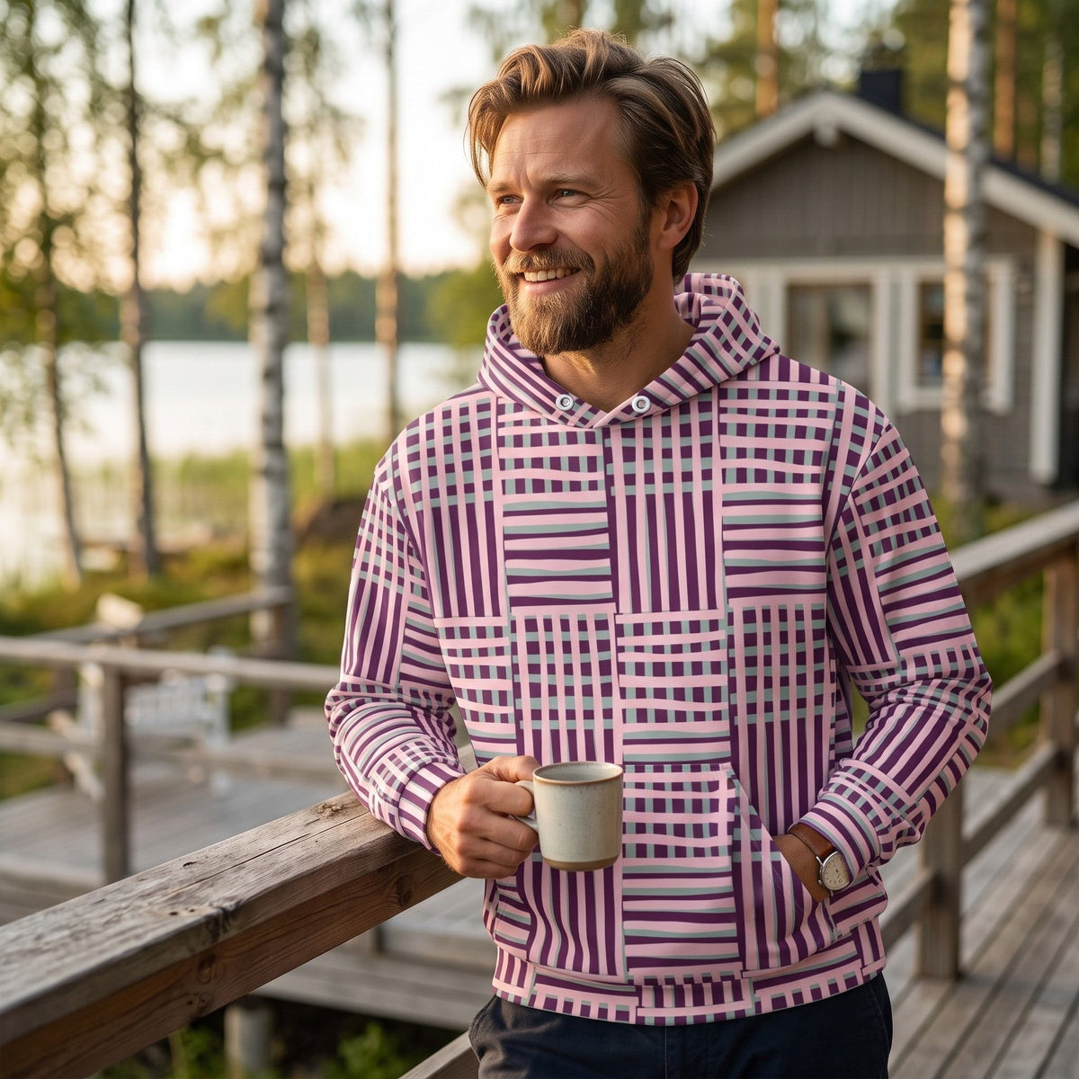 Good Wishes 365 recycled hoodie with purple and blue geometric stripes worn by a man on a wooden deck at sunset.