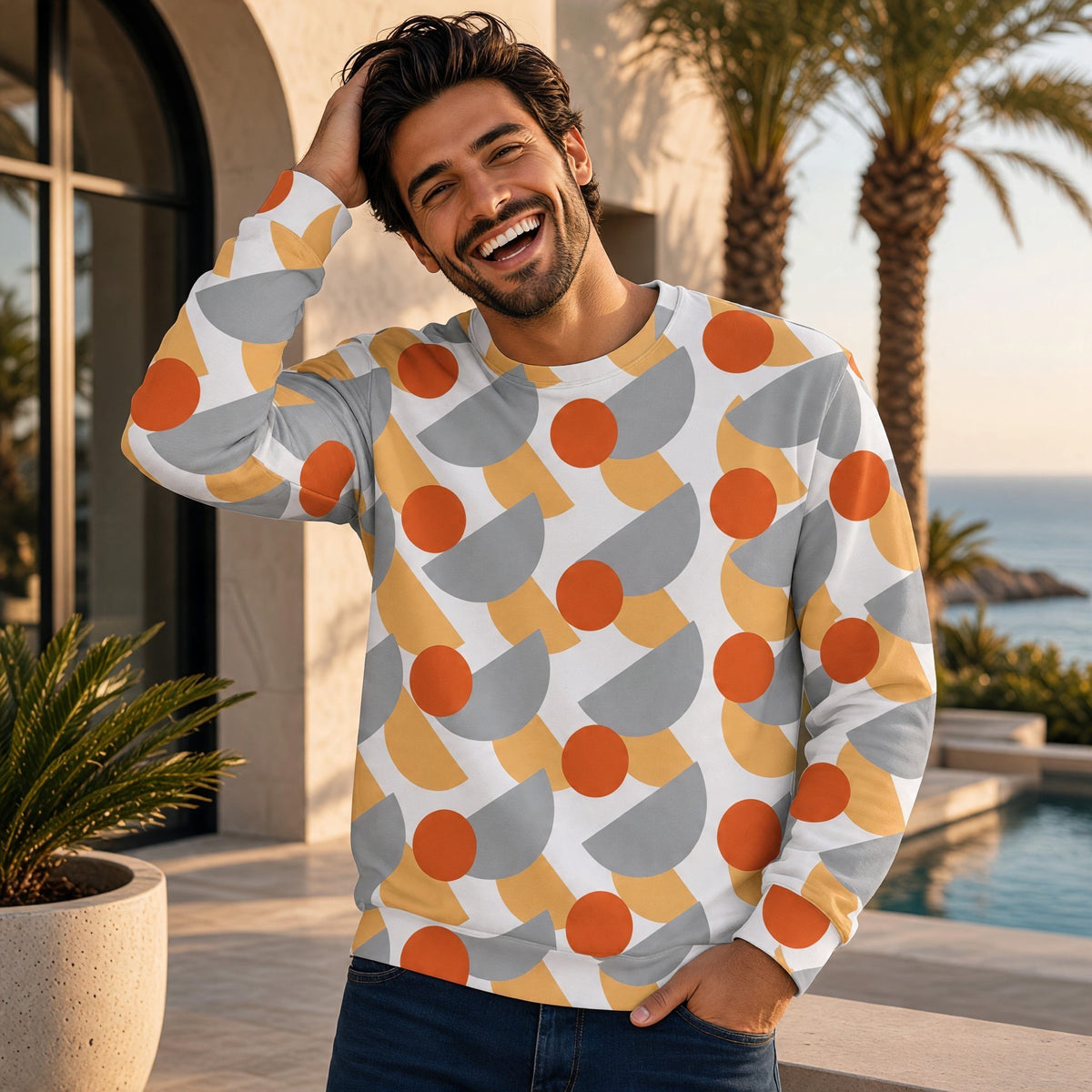 Good Wishes 365 recycled sweatshirt with orange, yellow, and grey geometric print worn by a smiling man outdoors.