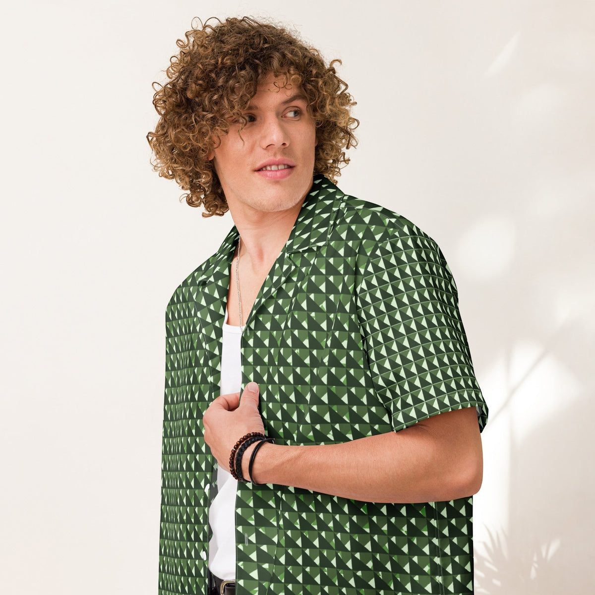 Good Wishes 365 men's short sleeve button shirt in green geometric triangle camo print worn by a curly-haired model