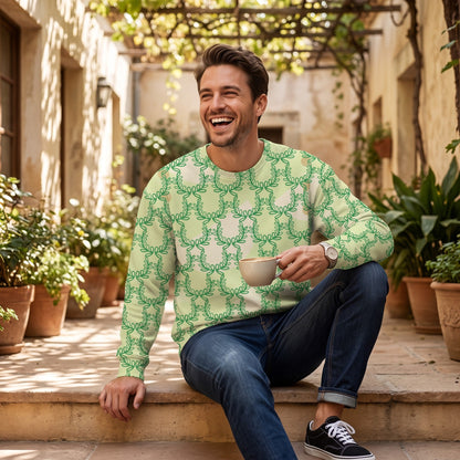Man wearing a Good Wishes 365 green laurel leaf print recycled sweatshirt while sitting outdoors with a coffee.