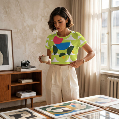 Good Wishes 365 green mushroom print crop tee worn by a woman holding a cup in a bright, modern studio setting.